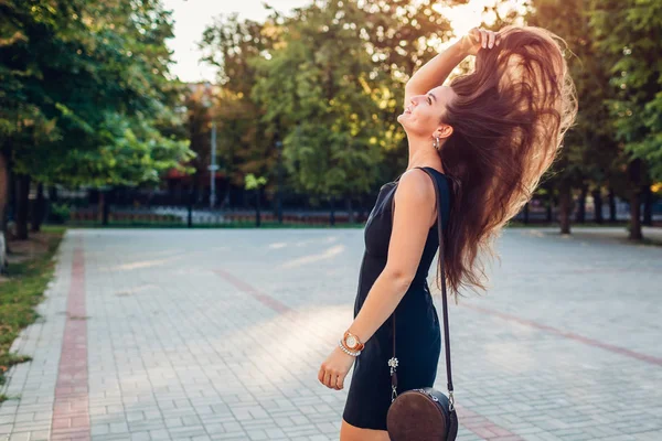 여름 공원에서 걷는 젊은 아름다운 여성. 그녀의 긴 건강한 머리를 던지는 세련된 여자. — 스톡 사진