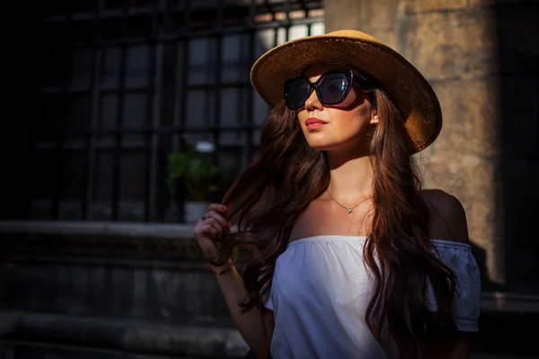 Modelo de moda. Retrato ao ar livre de jovem mulher bonita turista vestindo chapéu de palha e óculos de sol ao pôr do sol . — Fotografia de Stock