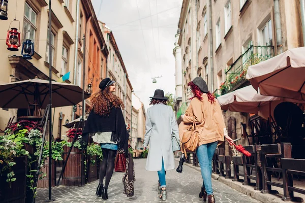 Chicas divirtiéndose. Foto al aire libre de tres mujeres jóvenes caminando por la calle de la ciudad. Vista trasera — Foto de Stock
