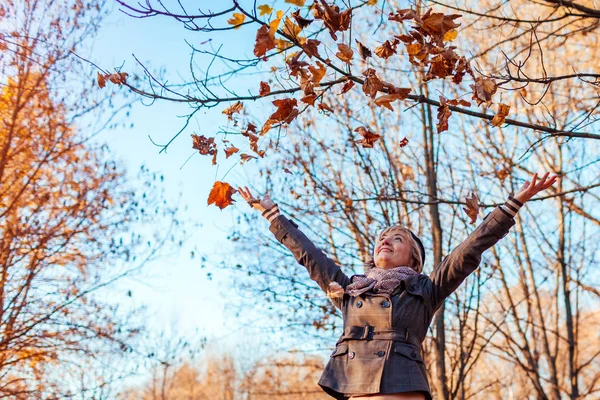 Fall activities. Middle-aged woman throwing leaves in autumn forest. Senior woman having fun outdoors — Stock Photo, Image