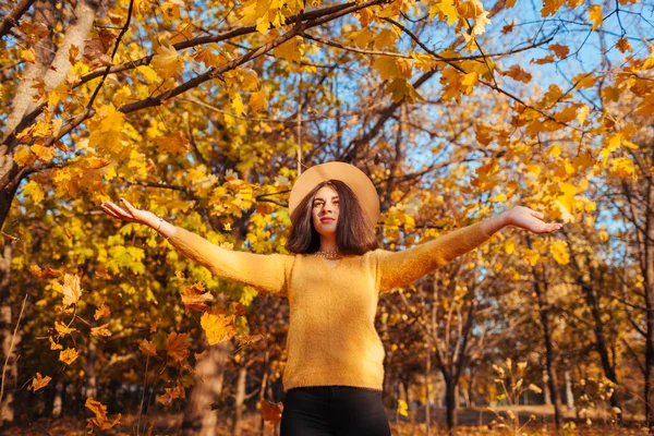 Actividades da época de Outono. Mulher jogando folhas na floresta de outono. Jovem mulher se divertindo ao ar livre — Fotografia de Stock