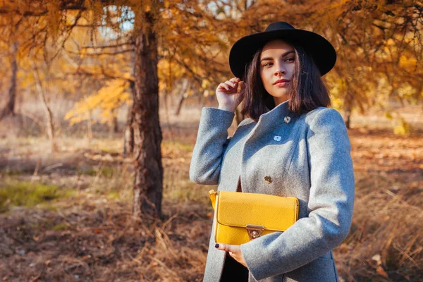 Jesienna moda. Młoda kobieta ubrana w stylowy strój i trzymająca torebkę na zewnątrz. Odzież i akcesoria — Zdjęcie stockowe