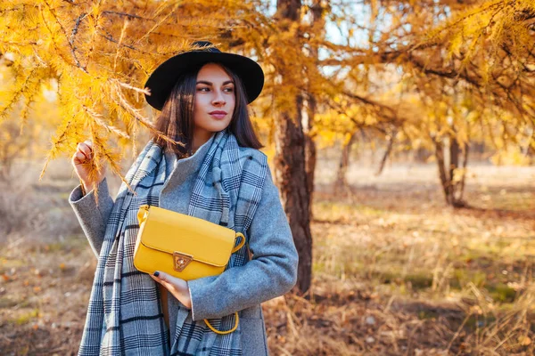 Jesienna moda. Młoda kobieta ubrana w stylowy strój i trzymająca torebkę na zewnątrz. Odzież i akcesoria — Zdjęcie stockowe