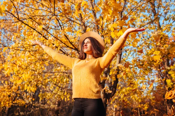 Actividades da época de Outono. Mulher jogando folhas na floresta de outono. Jovem mulher se divertindo ao ar livre — Fotografia de Stock