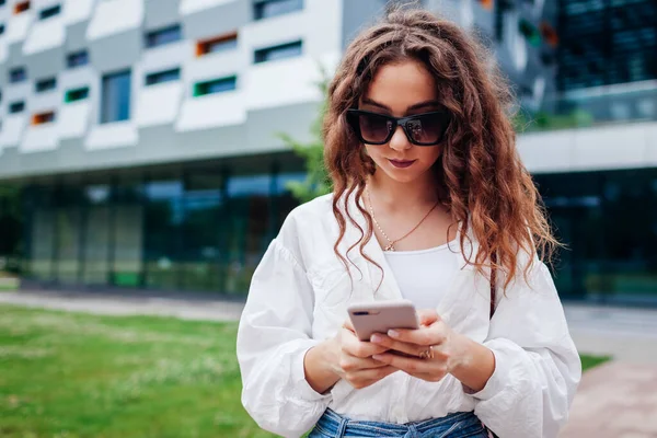 Üniversitenin dışında akıllı telefon kullanan genç bir öğrenci. İnternette mesaj yazan bir kız arıyor. Mobilyaları dışarıda tutan şık bir kadın.