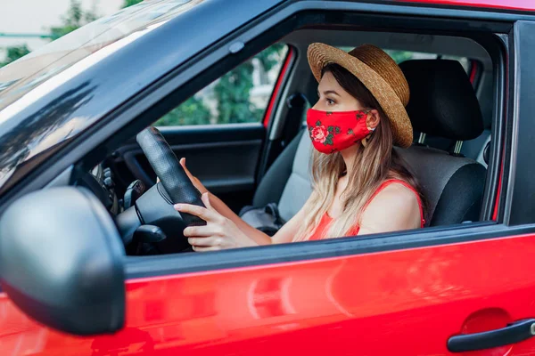 Kobieta Kierowca Siedzi Samochodzie Czerwonej Masce Ochronnej Podczas Pandemii Koronawirusa — Zdjęcie stockowe