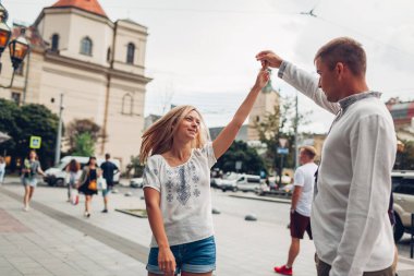 Âşık gençler eski Lviv şehir merkezinde geleneksel Ukraynalı gömlekler giyerek yürüyorlar. Çiftler eğleniyor.