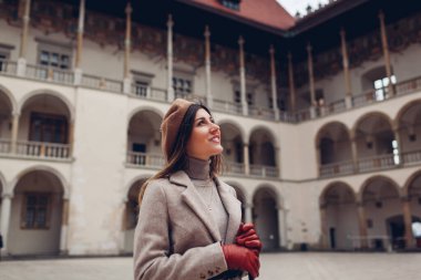 Polonya, Krakow 'daki Wawel Kalesi' nin avlusundaki manzaranın tadını çıkaran bir kadın turist. Gezgin mimariye hayran. Avrupa 'yı dolaşmak