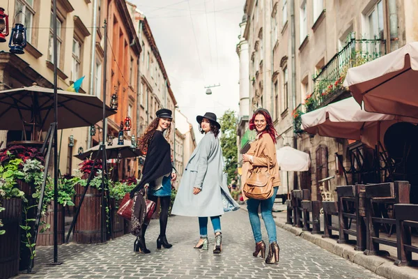 スタイリッシュな女性が街を歩いています 3人のガールフレンドがカフェでライブを楽しんでいます 秋のファッション — ストック写真