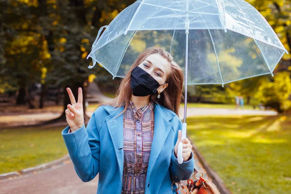 여성이 공원에서 우산을 코로나 바이러스 Covid 평화의 표징을 보이는 — 스톡 사진