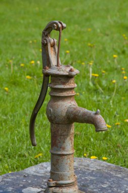 Eski bir çiftlik evinin bahçesinde duran yaşlı Schwengel çeşmesi