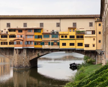 Ponte Vecchio Köprüsü iki tarafında inşa sarı boyalı evleri ile Floransa'da Arno Nehri üzerinde görünümü