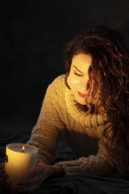 şenlik kızdırma bir mumla yüzünde tutan genç kız. Mutluluk ve umut ifade yansıtır