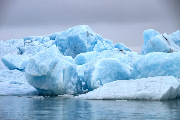漂浮在水面上的冰川的蓝色冰块与灰色的天空 — 图库照片