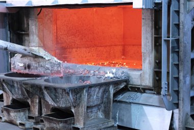 erimiş alüminyum döküm önce cüruf kaldırmak için gözden geçirme. Alüminyum döküm açık bir fırın gösteren çalışır