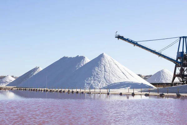 white salt mountains on blue background, with the pink lagoon in front of them due to the salt concentration