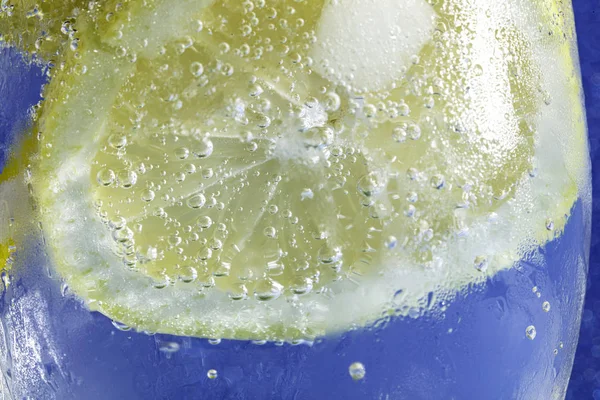 Газировка с лимоном на голубом макро — стоковое фото