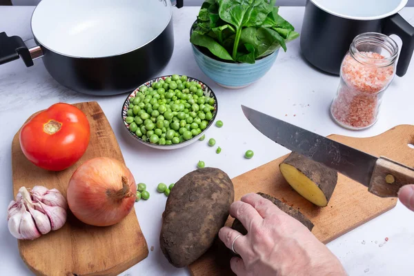 Pişirmek için patates ve diğer sebzeleri doğramak..