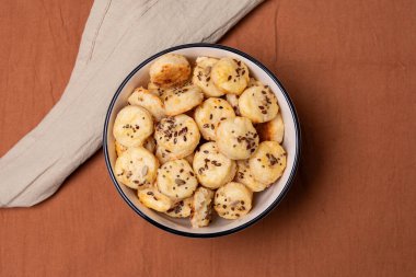 Ev yapımı peynirli krakerlerle dolu bir meyve kasesinin en üst görüntüsü..