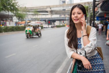 Ailesi bağlanıp onun hayatını onlarla paylaşmak için telefonda konuşurken Asyalı kadın backpacker.