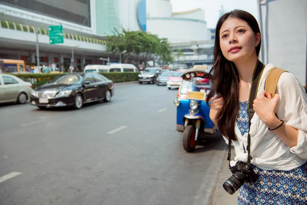 Asyalı kadın backpacker toplu ulaşım tuk tuk büyük CIT yolda yanı sıra bekliyor.