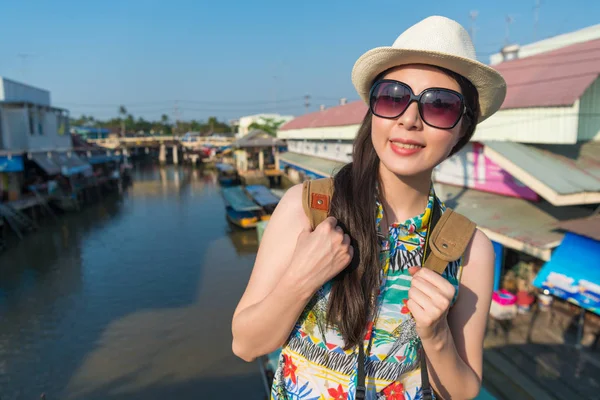 Asyalı kadın float ayakta arka plan Pazar ve bir fotoğraf çekmek için kameraya bak.