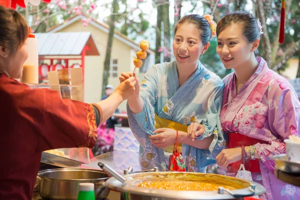 Asya genç bayanlar kızarmış köfte yanında sokak satıcısından satın alma.