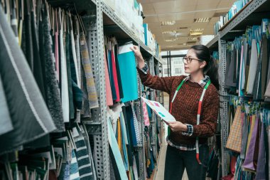 Asya profesyonel yönetim şerit metre ile depodaki doku örneği seçme.