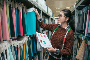 Asya profesyonel yönetim şerit metre ile depodaki doku örneği seçme. Envanter kontrol Çift Kişilik.