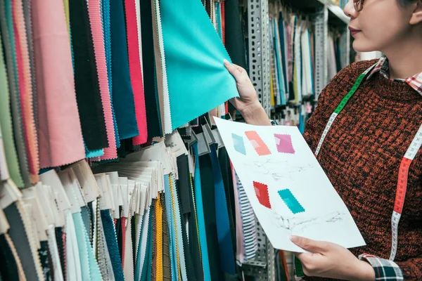 Yöneticinin el giysiler doku fabrikada seçerek çekim kapatın. O seçmek için hangi karton karar veriyor.