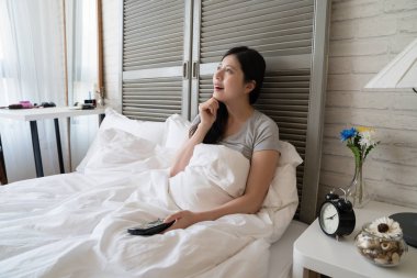 Asyalı kadın yatakta yatan ve o gelecekte ne olacak hakkında onu çene düşünme dokunmadan yan görünüm.