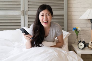 Kahkaha içine Asya kadın oturma yatak ve patlama. O gerçekten yüksek ruhtur. Onun üzerine band ve gülmeden edemedim.