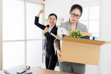 Asyalı kadın yönetici işten ve onun yerine resmi siyah takım elbise giyen genç bir yeni gelen Bayan tarafından alınır.