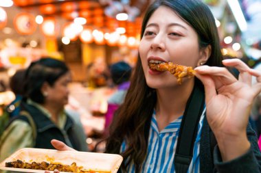 Asya ziyaretçi yemek ızgara tavuk. Japon pazarı arka tarafından.