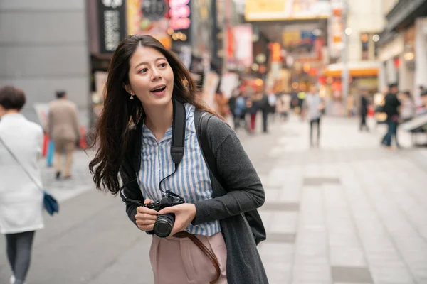 迷人的旅行妇女拿着相机愉快 从人群和街道观看 — 图库照片