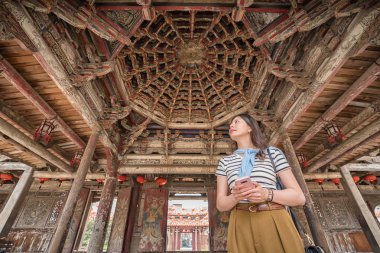 Eski güzel tapınakta duran Asya kadın. cep telefonu elinde tutan