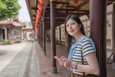Asyalı kadın bir akıllı telefon tutarak yan görünüm. bir gezi için arıyorsunuz 