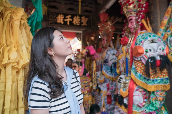 Asyalı kadın tapınakta gezi. Tanrı ve dini heykeller arka tarafından