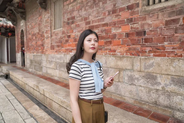 Asyalı kadın bir şey tarafından mobil arama. Onu bulmak için görünüyor.