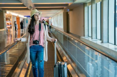 hareketli konveyör bant üzerinde duran ziyaretçi. kat yürüyen merdiven onun Bagaj taşıma kullanın. arka planda Havaalanı.