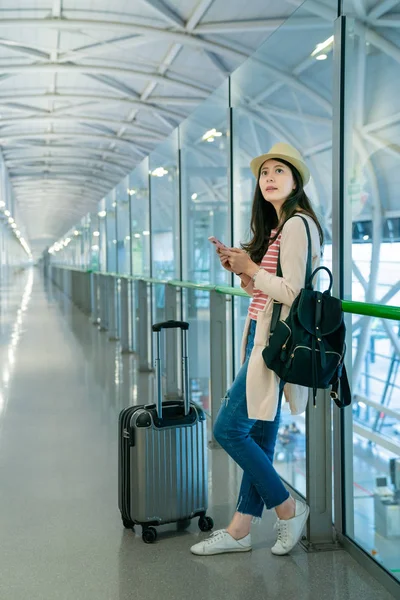 cam parmaklıklar yaslanmış bir kadın. Ona telefon tutarak ve karaya seyir.