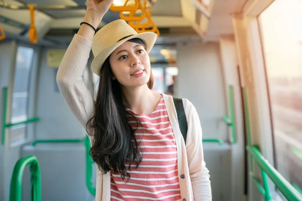 Küpeşte Tren içinde tutan kadın. Yarım vücut görünümü ile gülen yüz. 