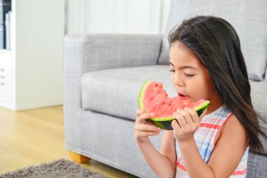 küçük bir dilim kavun yemek kız. tam memnuniyeti ile rahatlatıcı seyir. esinti tarafından üflenir saç.