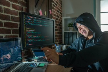bir banka kartı tutan ve vicously için hazır mısınız sonraki şantaj kurbanlarını üzerinde gülüyor kötü hacker.