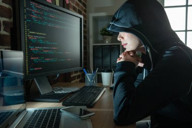 kadın hacker ekran gülümseyen bakıyordu. bilgisayar ve dizüstü düşünme önünde oturan nasıl dolandırıcılık için. 