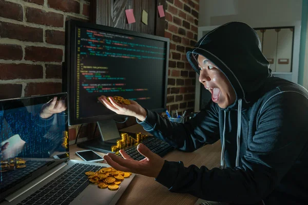 男性のハッカーは 強盗の身代金のために嬉しそうに笑って 彼の手で Bitcoin の杭をつかんでください — ストック写真