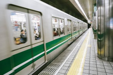 birçok kişi içinde oturan ile Japonya'nın osaka istasyonunda tren hareket görünümü.
