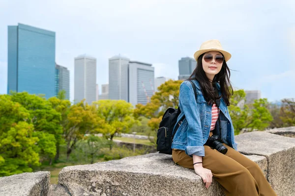 Stylische Ziemlich Asiatische Reisende Sitzt Auf Steinbühne Und Sieht Entspannt — Stockfoto