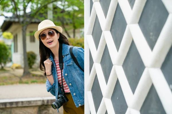 sevinçle kendini whit ızgaralar gösterilen gülümseyen genç şık turistik bir ünlü gezi yerde duvar.