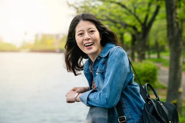 아시아 여자는 미소로 웃으면서 즐겁게 레일에 기대어 — 스톡 사진